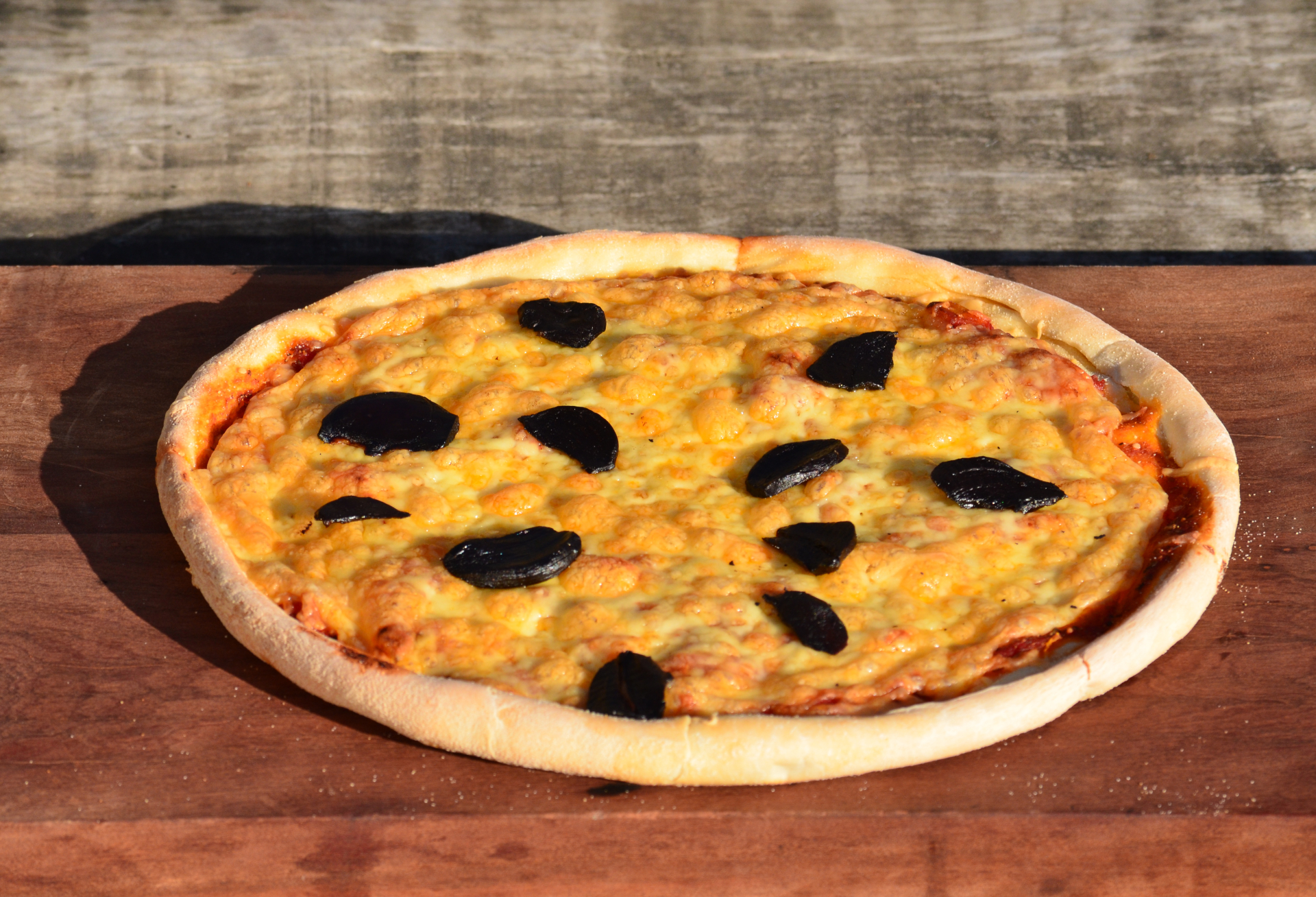 Pizza Margarita con láminas ajo negro